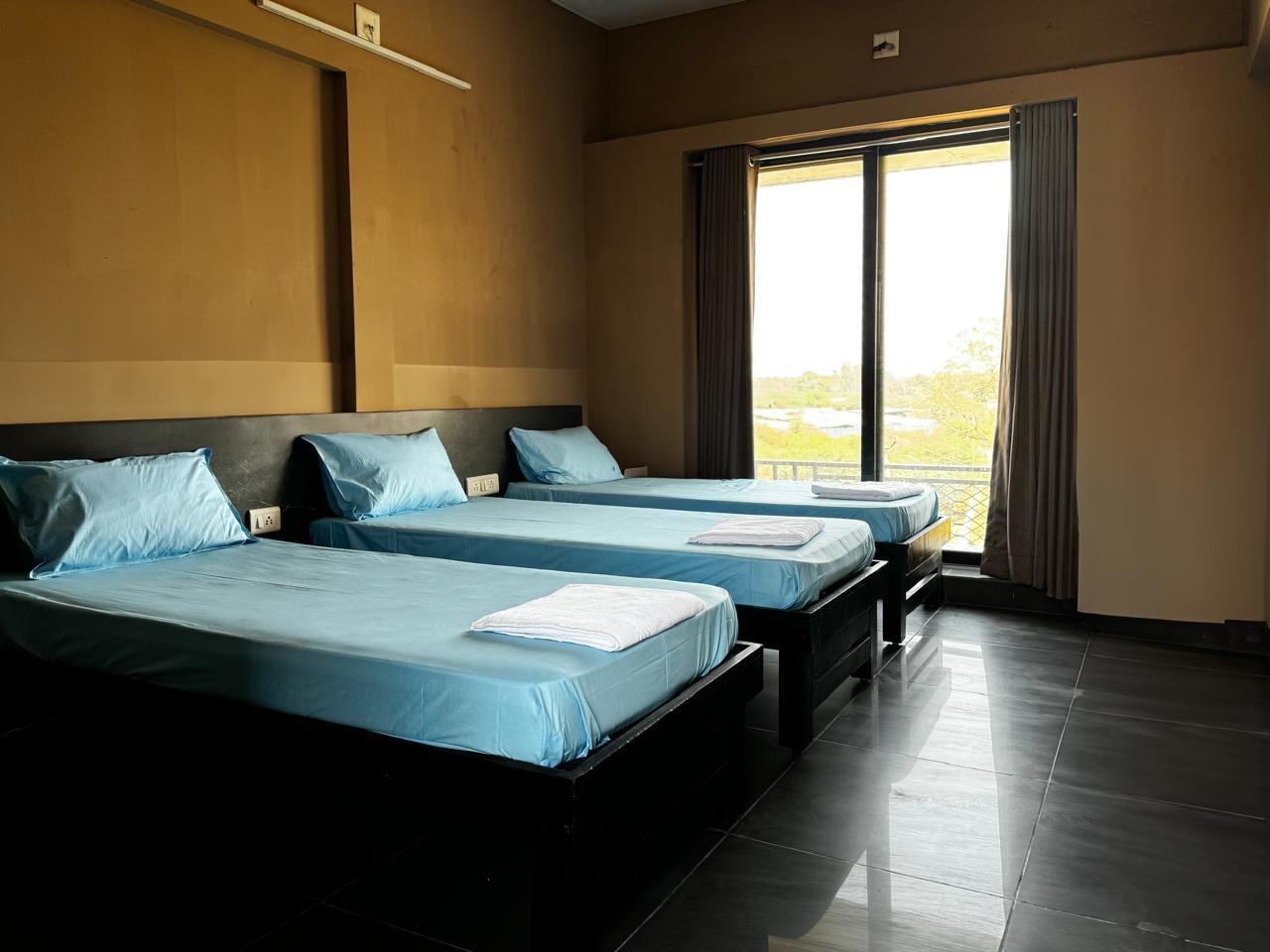 Triple sharing room with three beds, modern furniture, and warm lighting