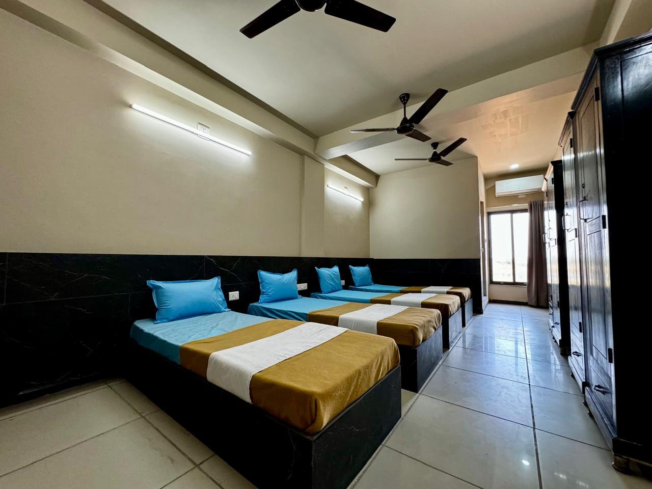 Quadruple occupancy room with four beds, bright and spacious with ceiling fan